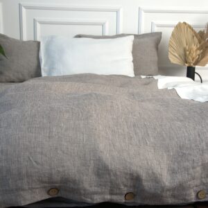 Duvet set of cacao melange duvet cover with decorative white lace and coconut buttons and two pillowcases with envelope closure.